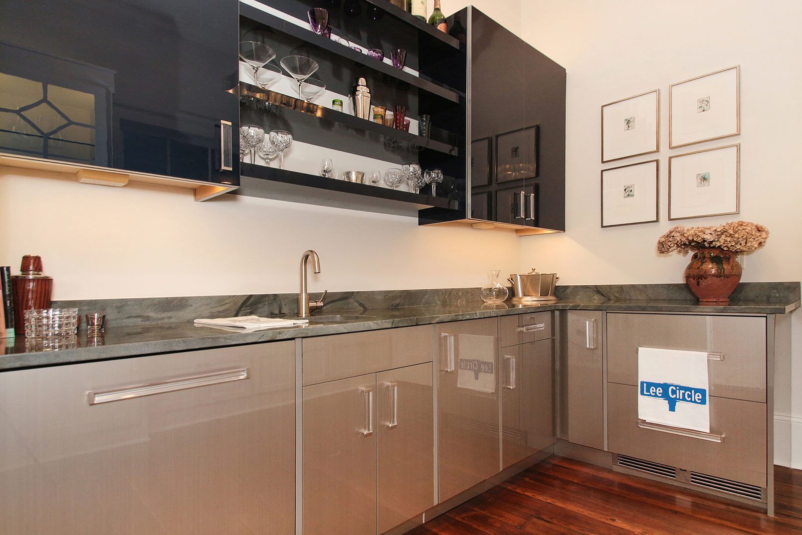 Custom wet bar with stone countertop and stainless cabinetry