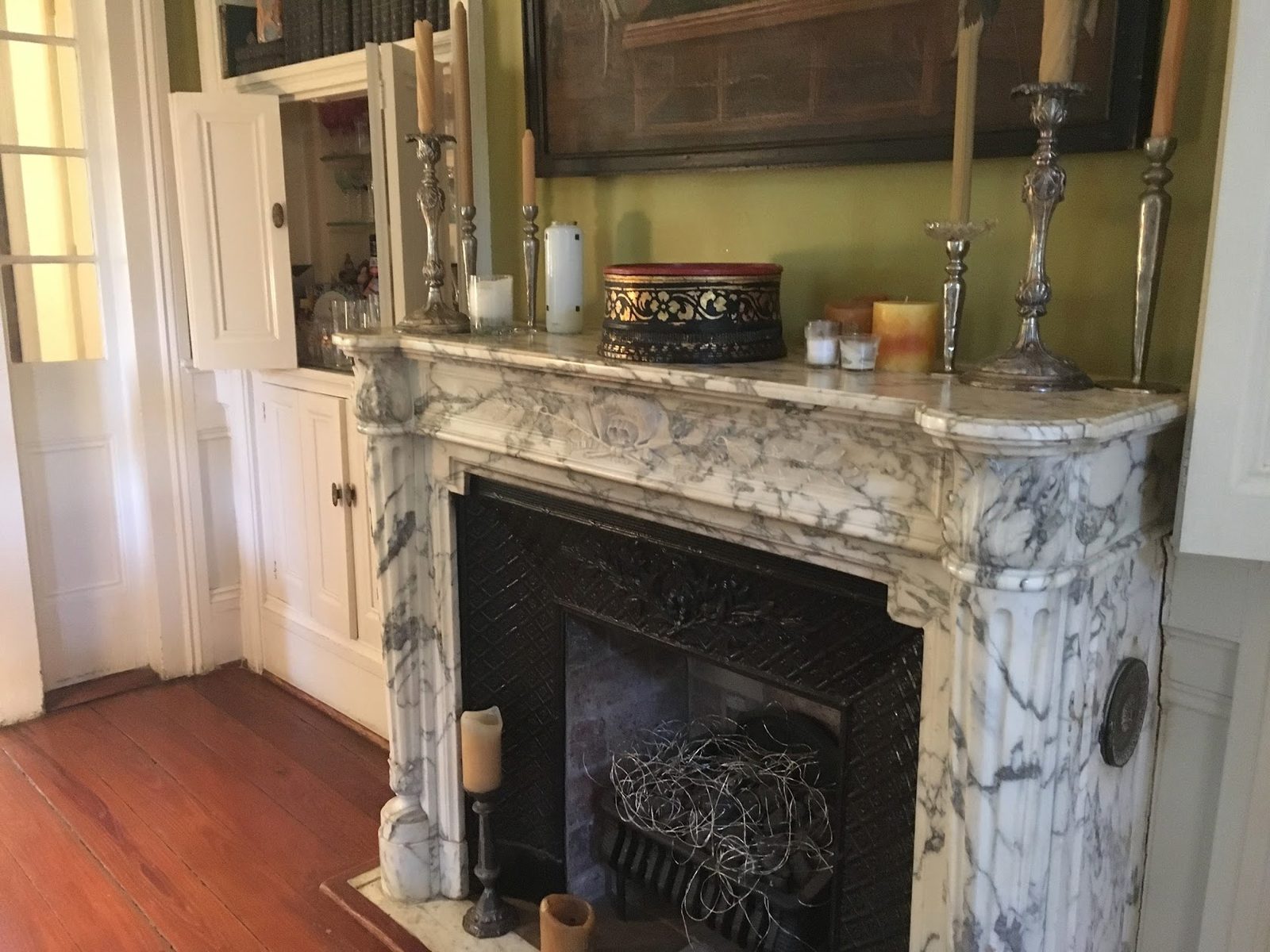 Original white Carrara marble mantel against olive walls before renovation