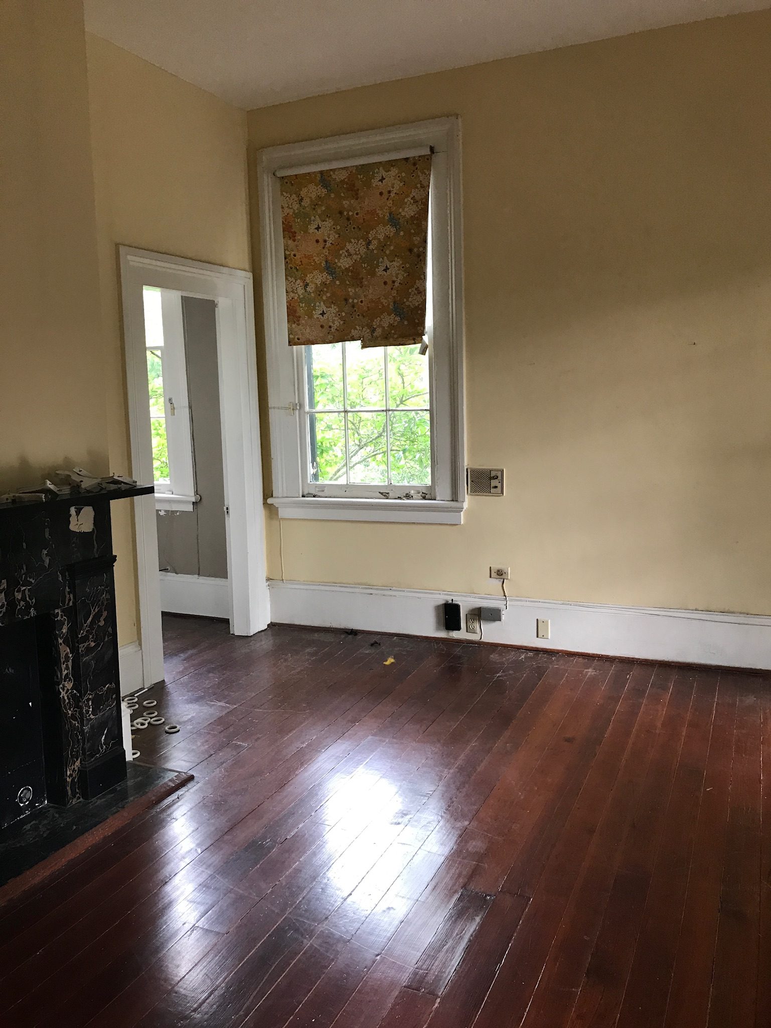 Garden District home before renovation - original heart pine floors and period mantel
