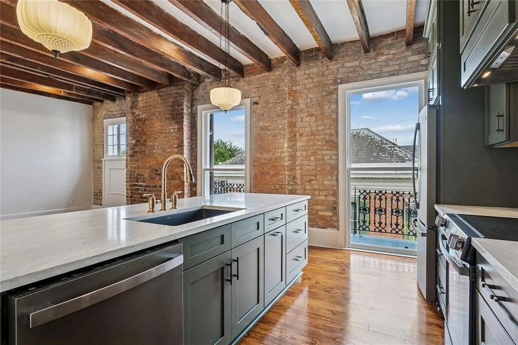 Kitchen under the original beams — historic Esplanade Avenue building renovated by DuCar Construction, New Orleans