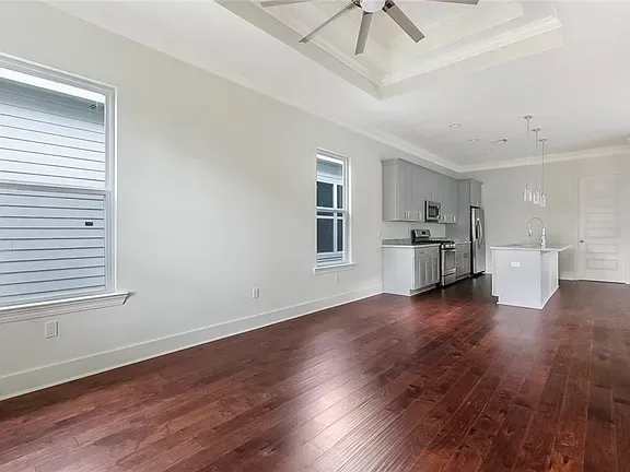 Open living room and kitchen with a tray ceiling in a DuCar new home in New Orleans
