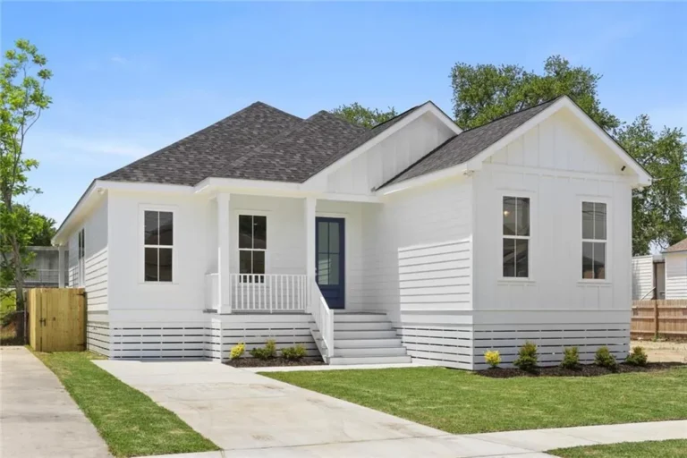 Four-bedroom new home in New Orleans by DuCar Construction with board-and-batten gables, a front porch and a raised foundation