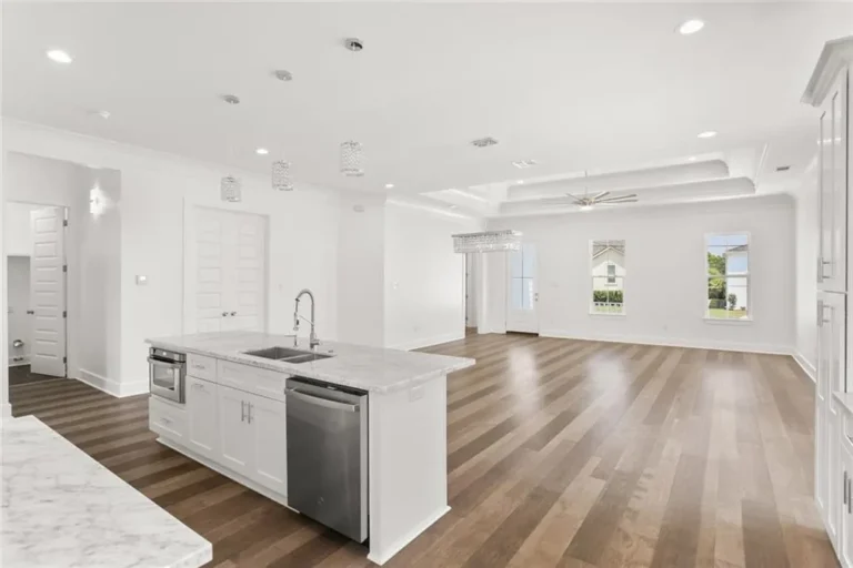Kitchen island with marble-look counters and crystal pendants in a DuCar new home in New Orleans